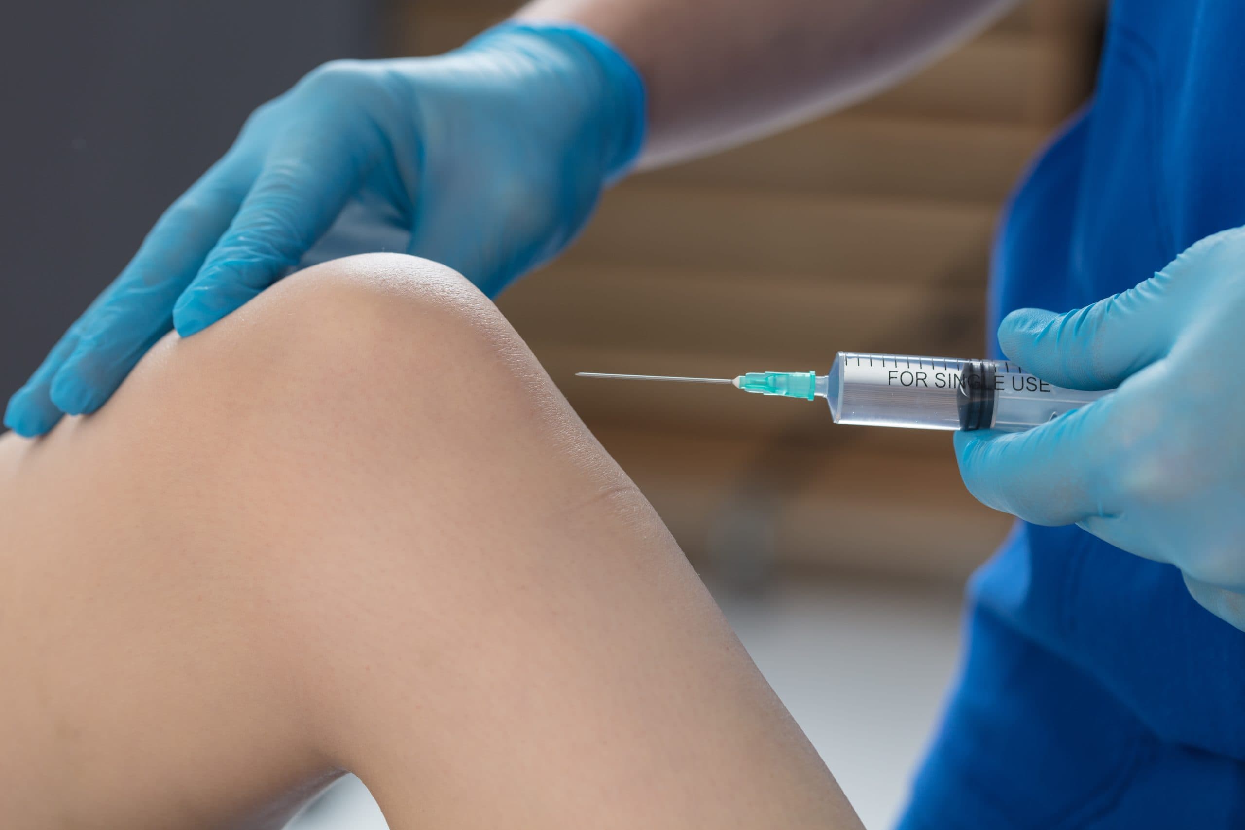 Clinician performing ultrasound-guided knee injection